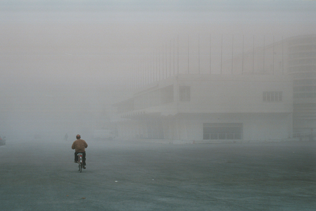 Uomo nella nebbia in bicicletta